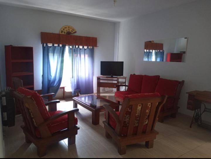 uma sala de estar com cadeiras vermelhas e uma mesa em Casa en Las Tapias cerca de Villa de Las Rosas em San Javier