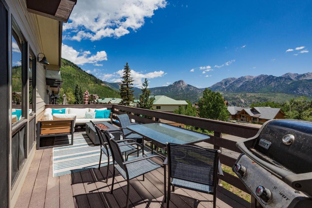 einen Balkon mit einem Tisch, Stühlen und einem Grill in der Unterkunft Sitzmark 5 in Durango Mountain Resort
