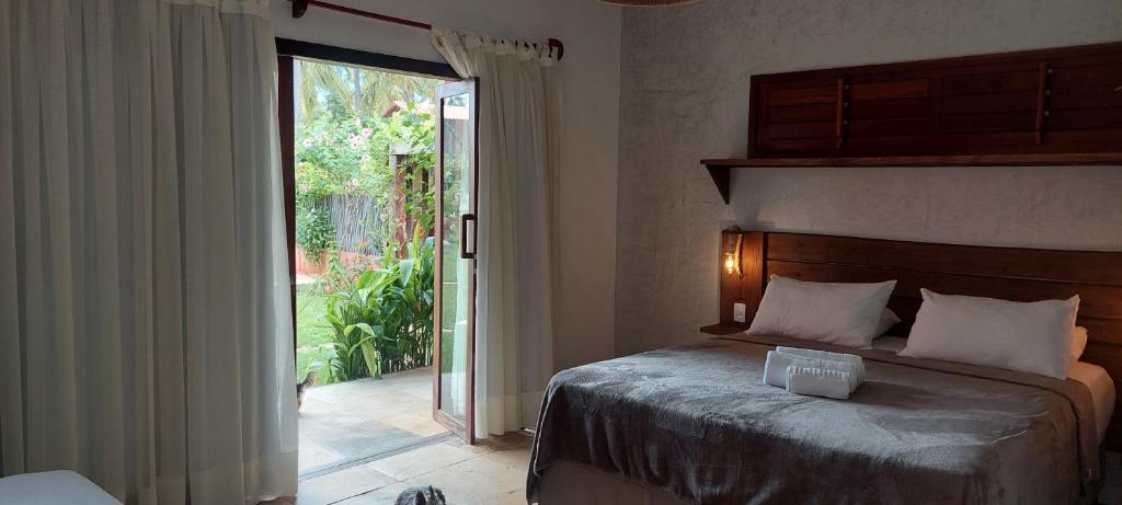 a bedroom with a bed and a sliding glass door at Pousada Flor de Lena- Lotus in Icaraí