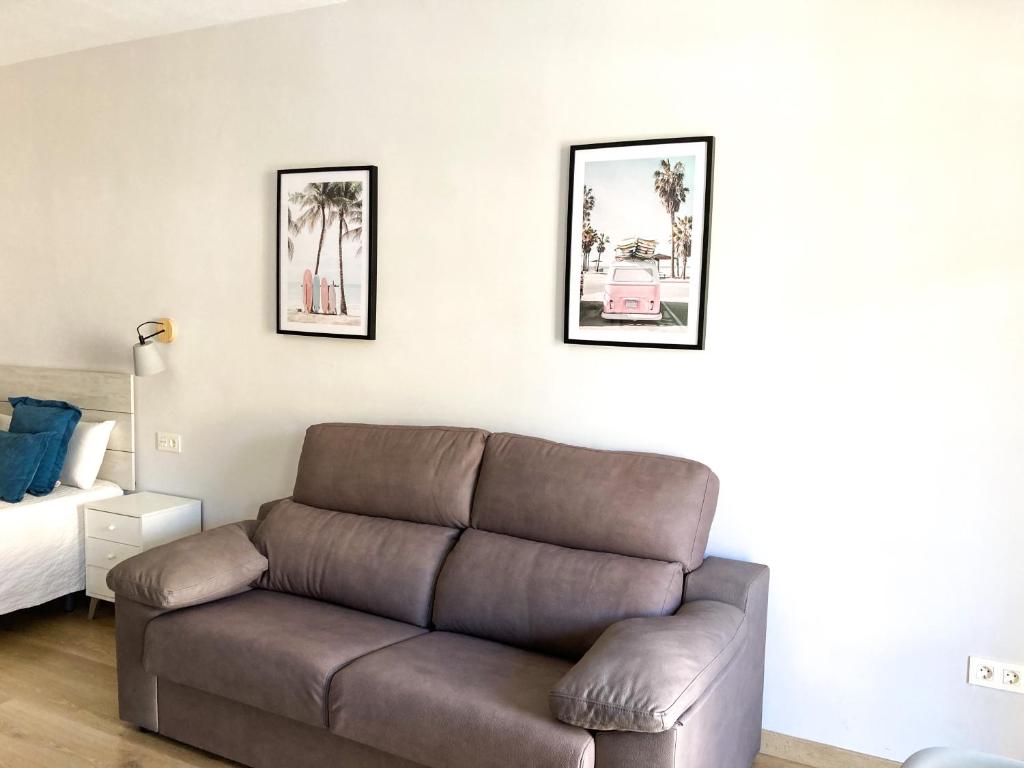sala de estar con sofá y cama en La Nogalera, en Torremolinos