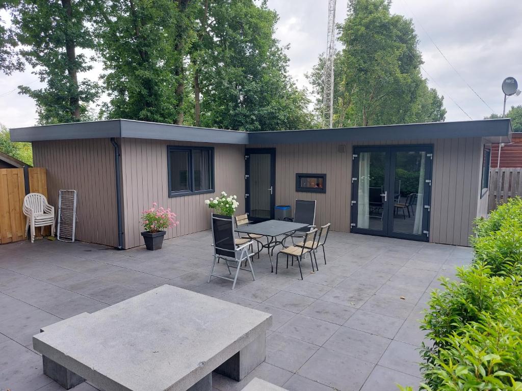 a patio with a table and chairs and a building at Chalet Moderna Putten in Putten