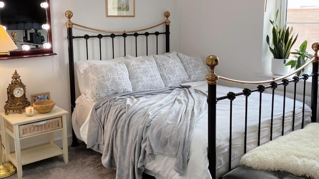 a bedroom with a black bed with white pillows at Entire home: Bicester Village 10min walk (650m) in Bicester