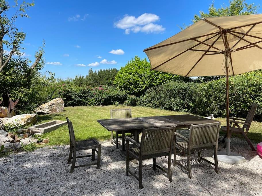 una mesa de madera con sillas y una sombrilla en Secret Hideaway with picturesque Sundown Views, en Traben-Trarbach