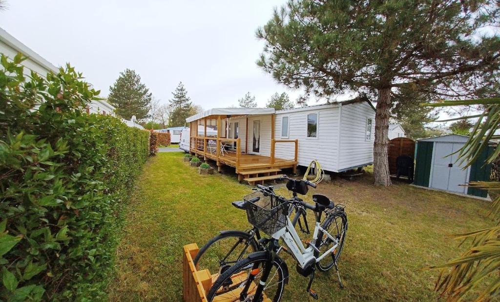 ein Fahrrad, das auf einem Hof neben einem Wohnwagen geparkt ist in der Unterkunft Ma pause Charentaise in Les Mathes