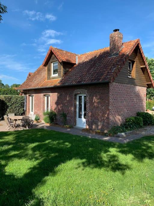 une maison en briques avec une cour d'herbe devant elle dans l'établissement Maison chaleureuse à proximité de la mer, à Sainte-Marguerite