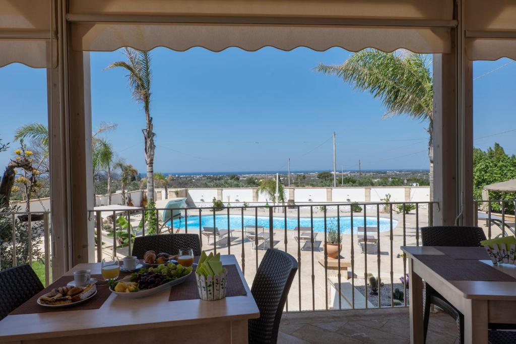 jadalnia ze stołem i widokiem na basen w obiekcie Arbor Exclusive B&B w mieście Ugento