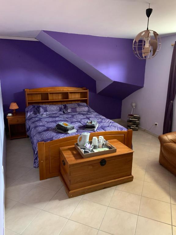 una camera con letto viola e struttura in legno di chadisietmaintenant a Montagne