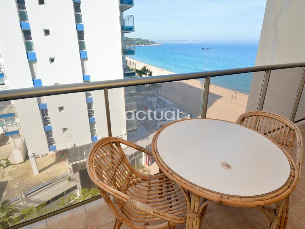 un tavolo e sedie su un balcone con vista sulla spiaggia di PRESIDENT C-6 a Platja  d'Aro