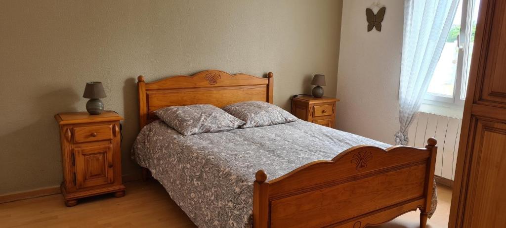 a bedroom with a wooden bed and two night stands at TI BIHAN TIEGUEZH in Île de Batz
