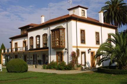 una gran casa blanca con una palmera delante de ella en Hotel Quinta Duro, en Cefontes
