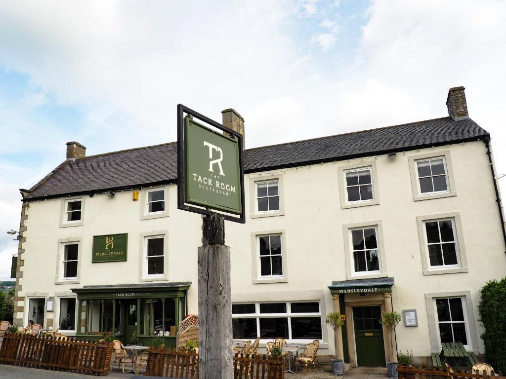 un letrero de la calle frente a un edificio blanco en The Wensleydale Hotel, en Middleham