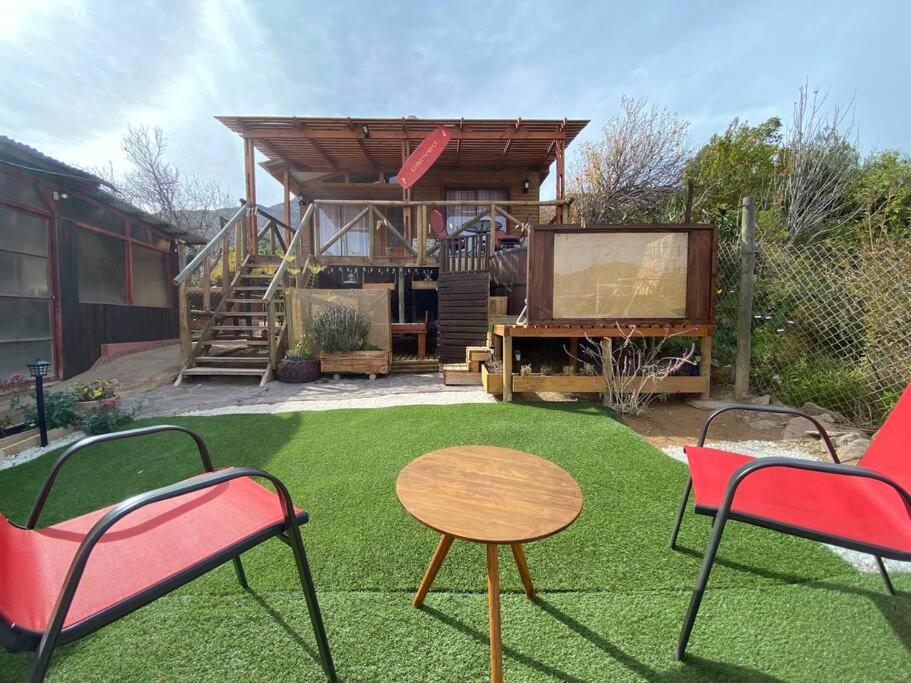 um quintal com duas cadeiras e uma mesa e uma casa em Cabaña Vientos del Puclaro em Vicuña