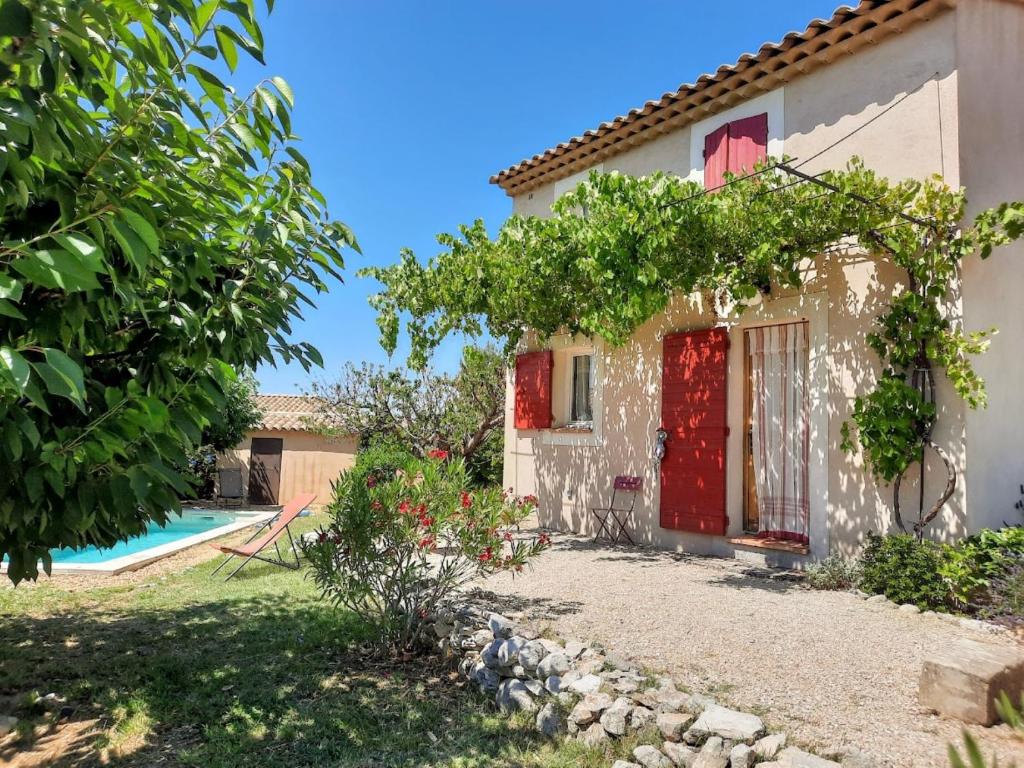 una casa con una porta rossa e un cortile di Le Petit Mas des Hauts de Beyssan, Maison de vacances avec piscine privative pour 2 personnes a Gargas