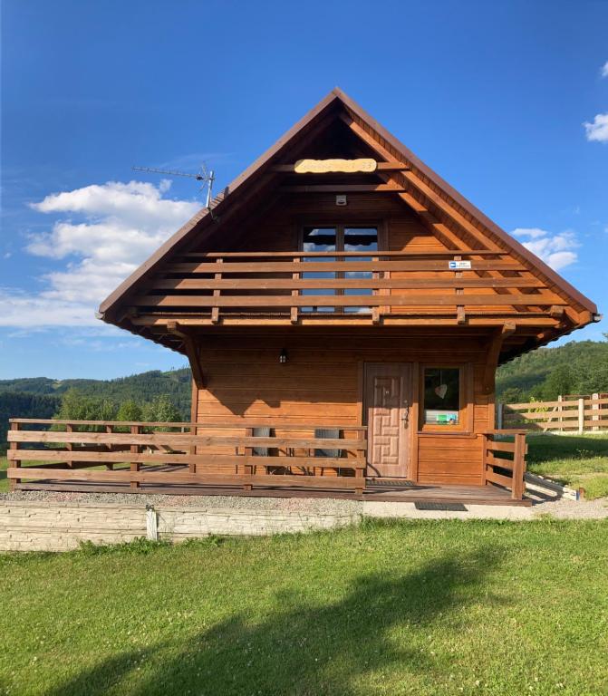 een grote houten hut met een groot dak bij "U Kamińskich" in Przyborów