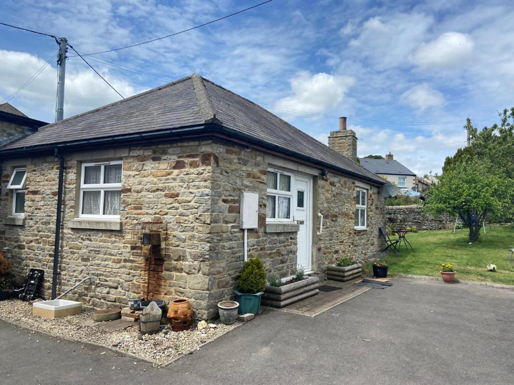 a small stone house with aphaltphaltphaltphaltphalt at Cosy 1-bedroom cottage with indoor open fireplace in Westgate