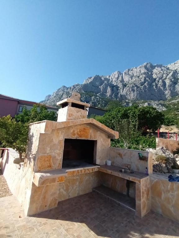 an outdoor pizza oven with mountains in the background at Vila Neve 87 Apartman in Veliko Brdo
