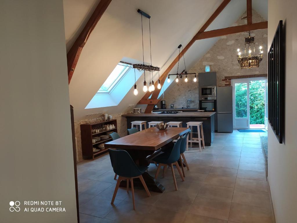 a large kitchen with a wooden table and chairs at La Longère du Val in Tauxigny