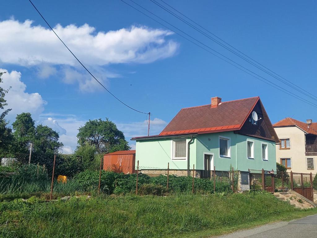 a house with a red roof on a street at Apartmán U jelena in Zvole