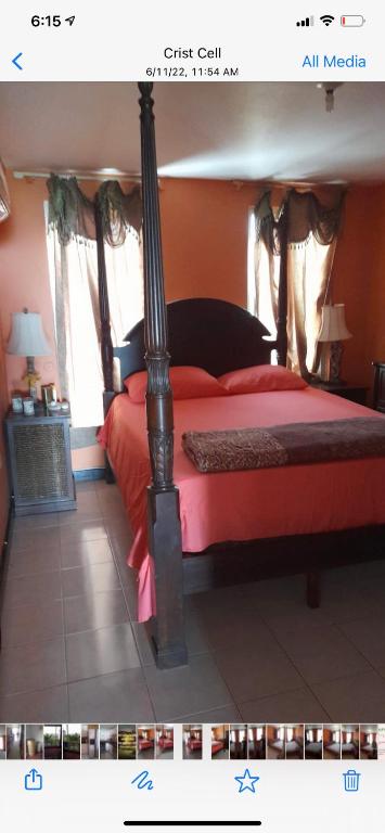 a bedroom with a bed with a red bedspread at Luxury Villa rentals in Montego Bay