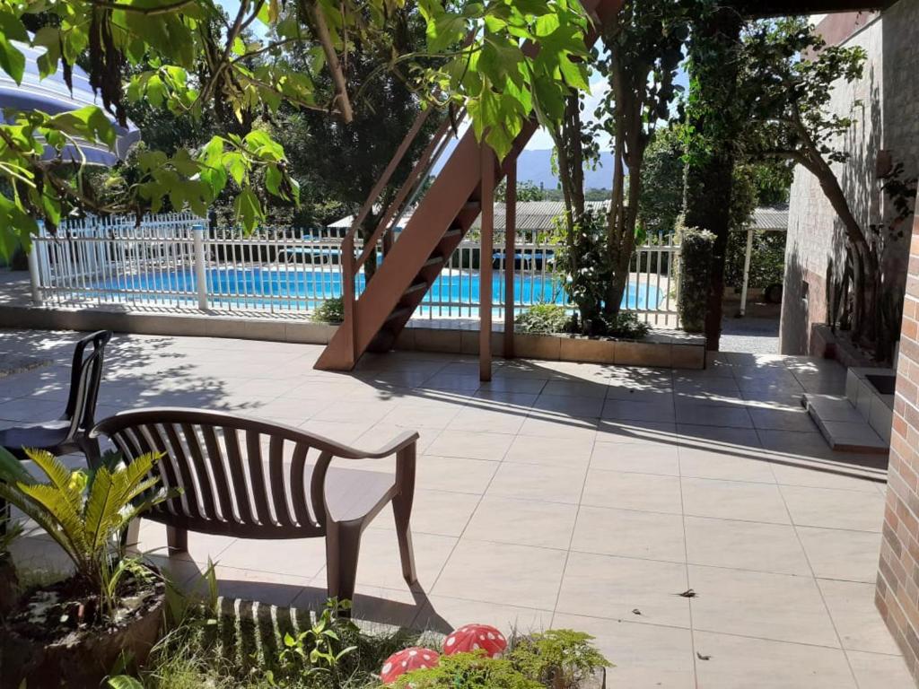 un banco sentado frente a una piscina en Pousada Martanha, en Porto Belo