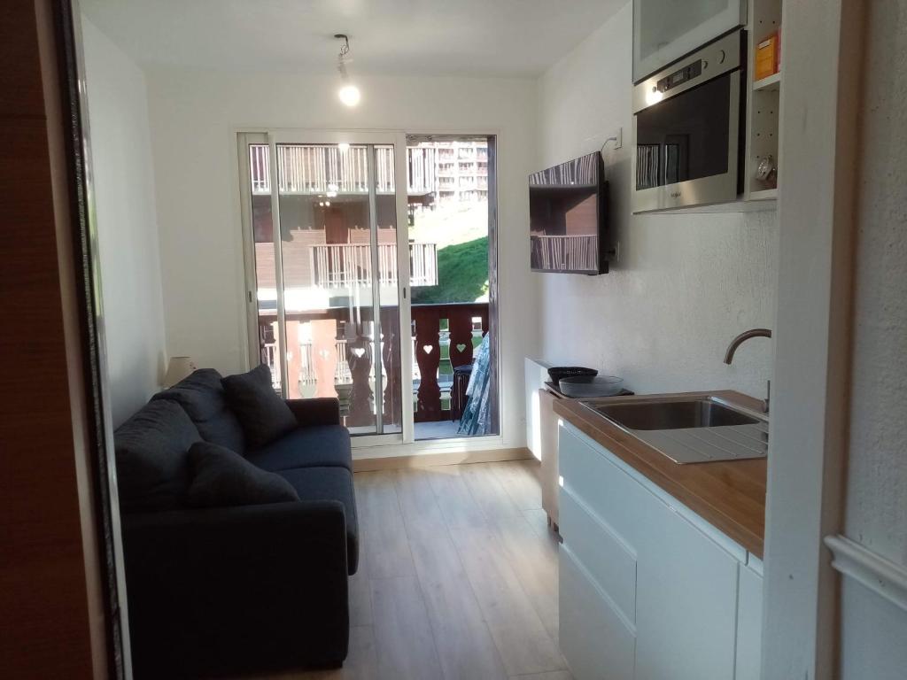 un salon avec un canapé et une cuisine dans l'établissement Tignes - Charmant studio pour 2-3 personnes proche des pistes, à Tignes