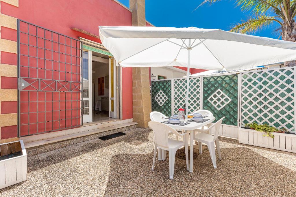 - une table et des chaises avec un parasol sur la terrasse dans l'établissement Villa Aurora by BarbarHouse, à Porto Cesareo