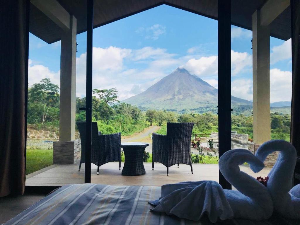 a view of a mountain from a room with swans at Arenal Roca Suites in Fortuna