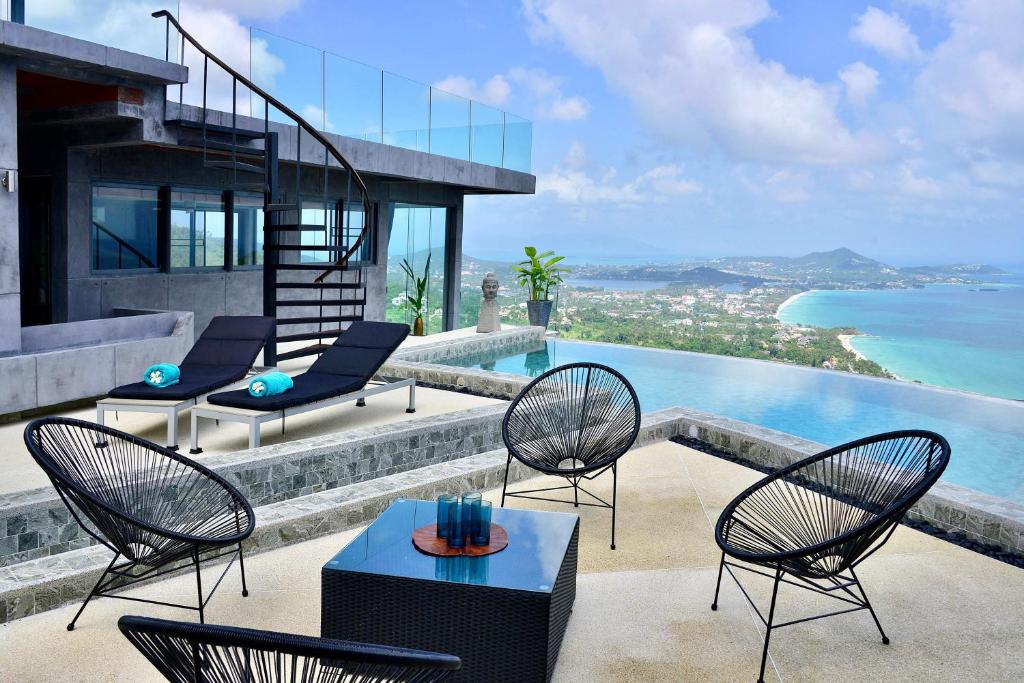une terrasse avec des chaises, une table et une piscine dans l'établissement Paradise Villa Elysium, à Koh Samui 