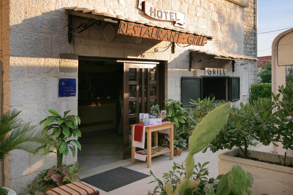 een hotel met een bord aan de voorzijde van een gebouw bij Hotel Trogir in Trogir