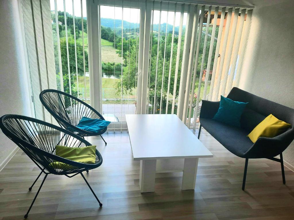 sala de estar con 2 sillas y mesa blanca en Guest House Šobić, en Šipovo