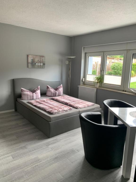 Schlafzimmer mit einem Bett mit rosa Kissen und einem Tisch in der Unterkunft Ferienhaus Bülow in Thale