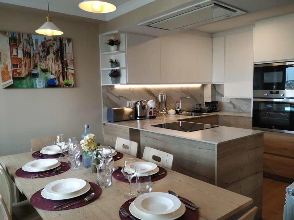 a kitchen with a wooden table with plates on it at EL CAPRICHO - LUJO Y CONFORT EN EL CENTRO con PARKING INCLUIDO in Gijón