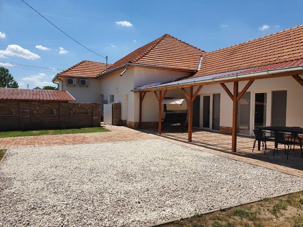 a house with a patio with a table at Família Apartman Cserkeszőlő in Cserkeszőlő