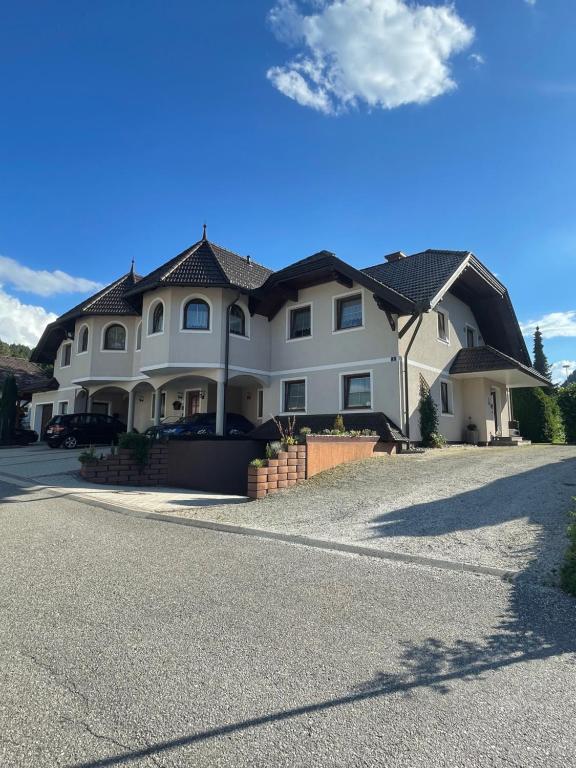 a large white house with a driveway at Haus zum Glück in Reifnitz