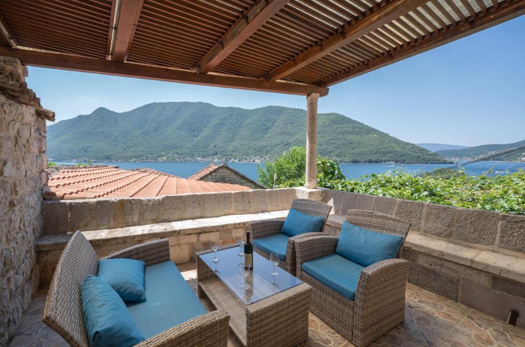 a patio with chairs and a table and a view of the water at Apartments Franovic in Perast
