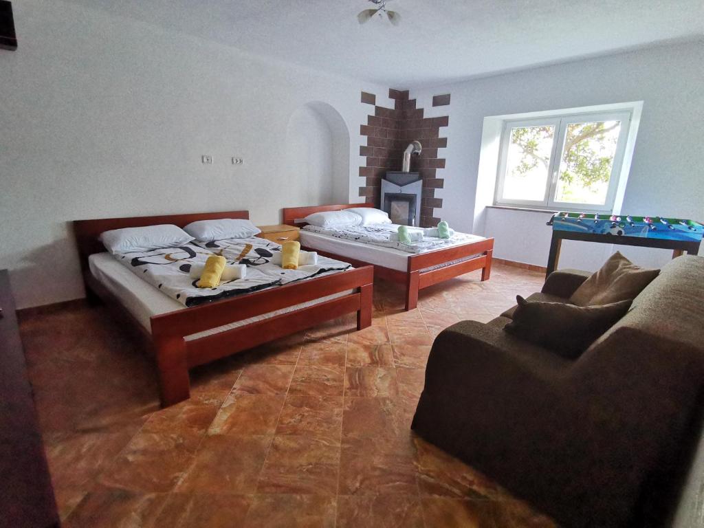 a living room with two beds and a table at APARTMA VATOVEC in Ankaran