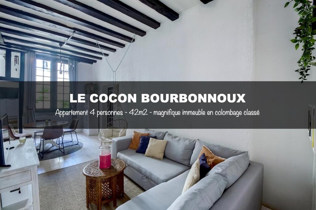 een woonkamer met een bank en een tafel bij Le cocon Bourbonnoux in Bourges