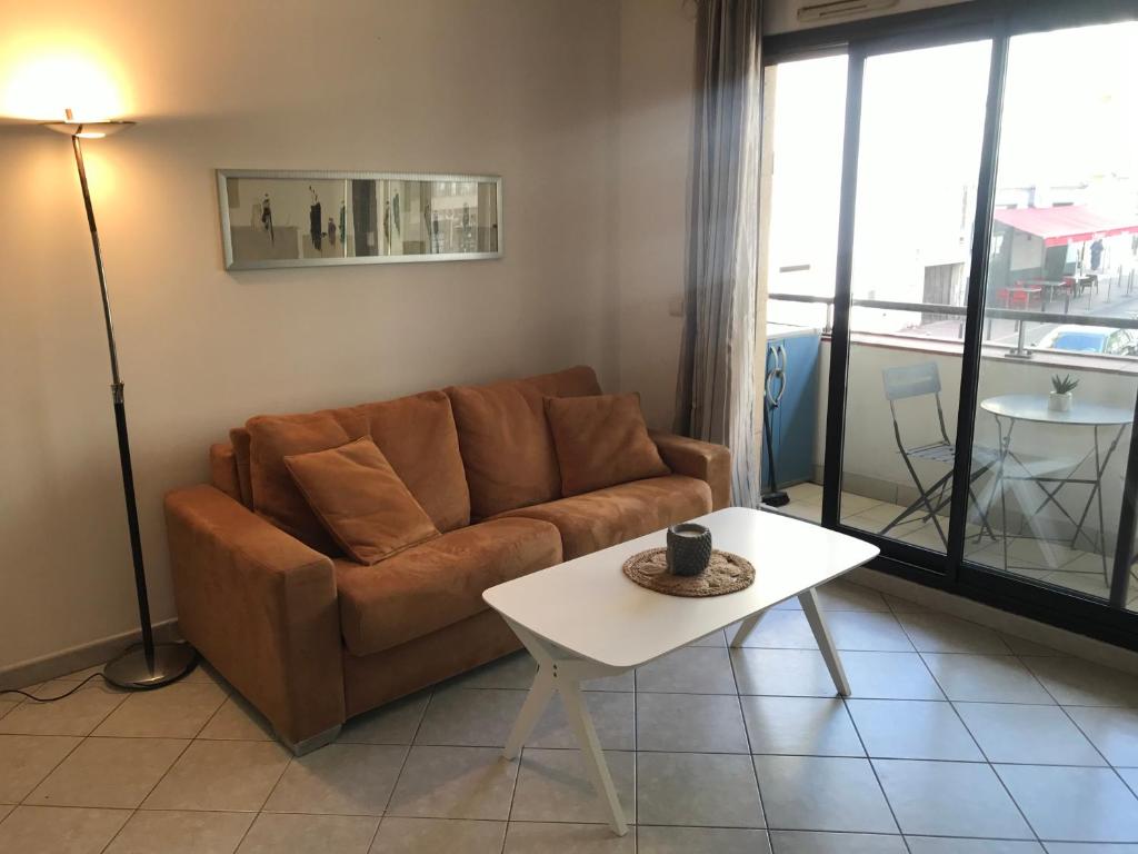 un salon avec un canapé et une table dans l'établissement Studio w/ balcony ideal for congress & holidays, à Cannes