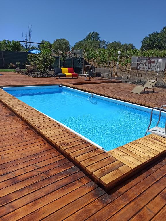 een zwembad met een houten terras en een blauw zwembad bij Tenuta sul Vesuvio " Il Vigneto " in Terzigno