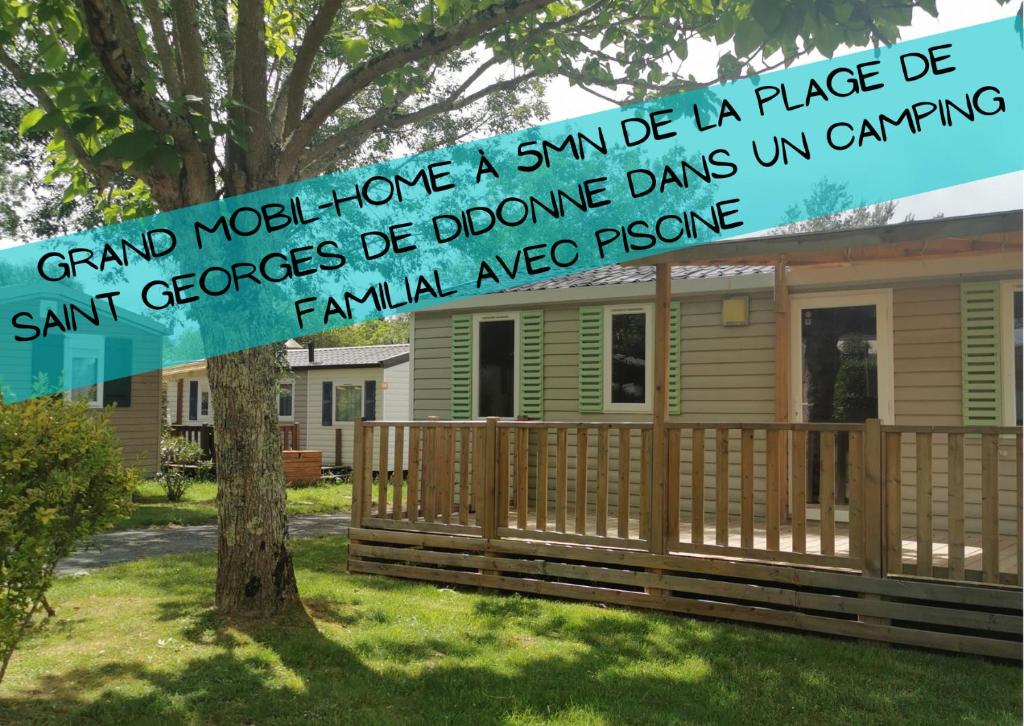 a sign on a tree in front of a house at Cosy Lili - Mobilhome MANDARINE - Proche océan in Saint-Georges-de-Didonne