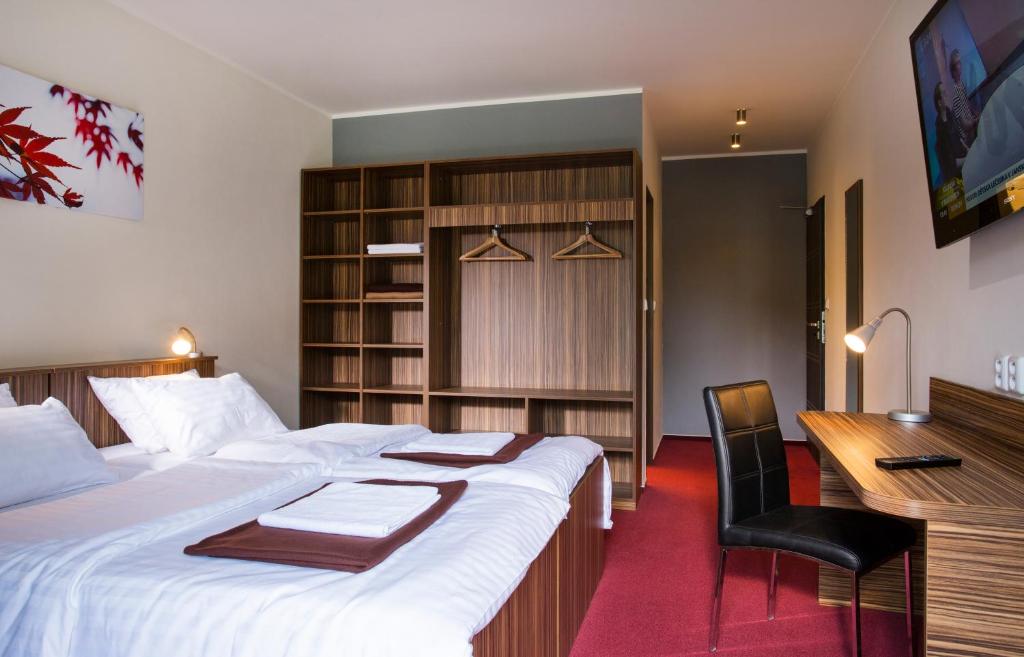 a hotel room with a large bed and a desk and a desk at Penzion Acrobat Park in Štíty