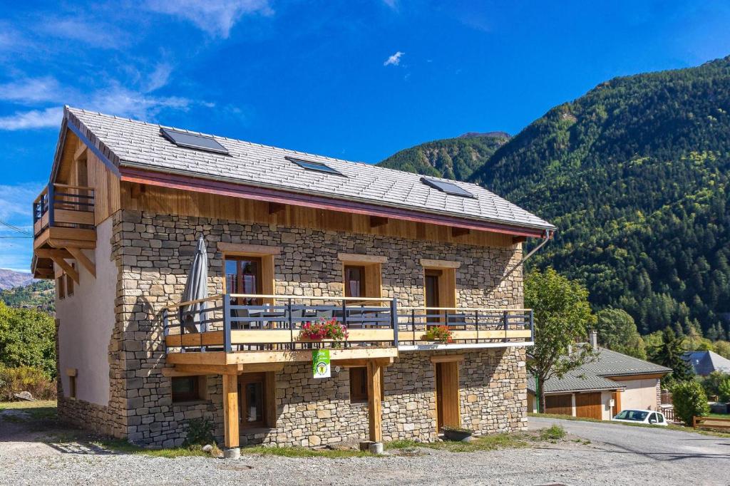 a building with a balcony and mountains in the background at GITE COSTE BELLE in Pont-du-Fossé