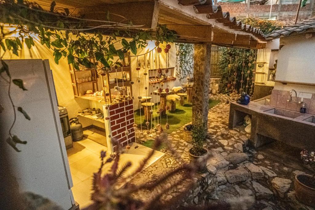 an outdoor kitchen and dining area of a house at MAMA GREEN Veggie Hostal & Permaculture Farm in Urubamba