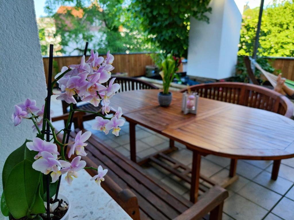- une table et un banc en bois sur une terrasse fleurie dans l'établissement Haus La-Vi in See Nähe, à Bregenz