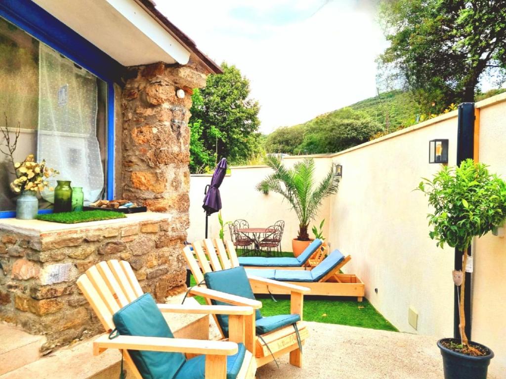 - un ensemble de chaises assises sur une terrasse dans l'établissement Les Rêves d'Eden Gite dans Mas Cévenol -SPA privatif, à Carnoulès