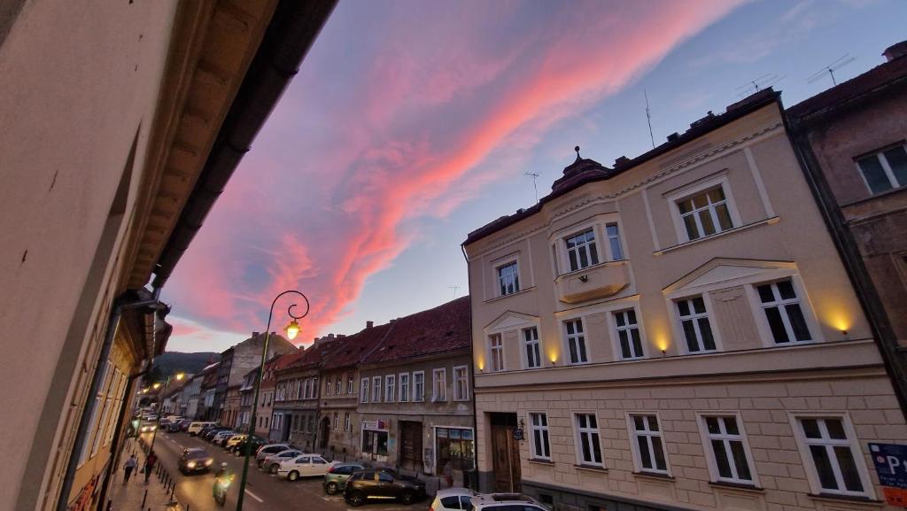 una vista del cielo nublado desde una calle con edificios en Casa Balcescu en Braşov
