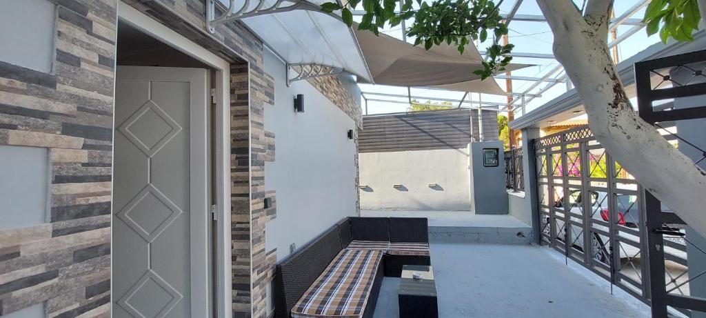 eine Eingangstür eines Hauses mit einer Veranda in der Unterkunft Litsa Galaxy Apartment in Artemida