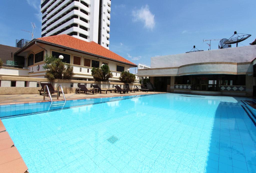 una gran piscina junto a un edificio alto en The A.A. Pattaya Residence, en Pattaya central