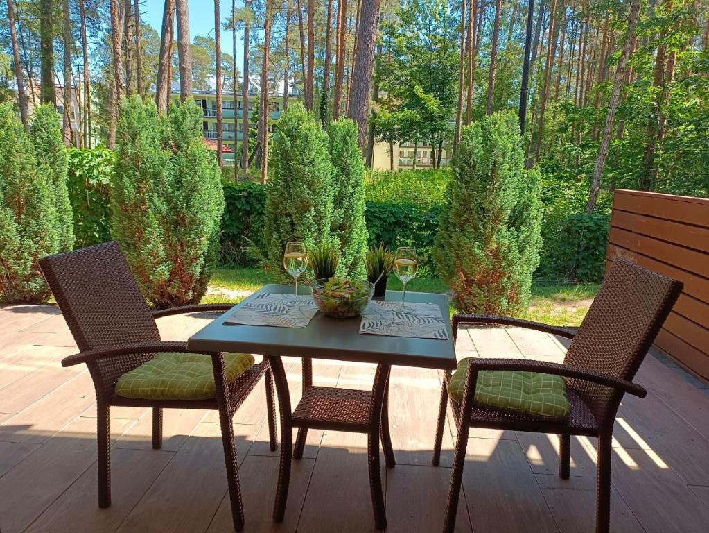 a table with two chairs and two glasses of wine at Apartament Rodzinny Baltic Park Stegna in Stegna