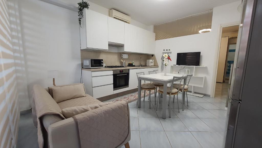 a living room and kitchen with a couch and a table at Residenza La Gazza e Spiaggia in Cervia